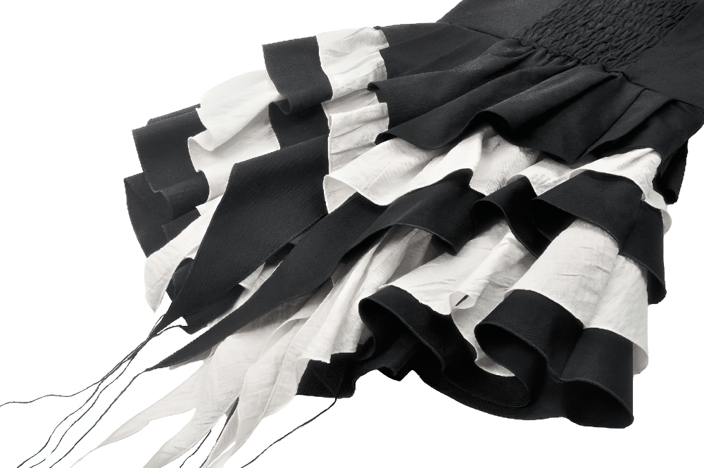Close-up of a black and white ruffled gothic dress showcasing layered fabric and intricate texture.