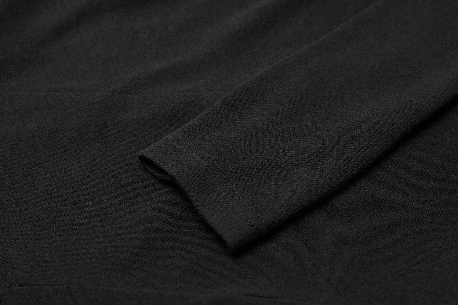 Close-up of a black knit dress sleeve showcasing the sleek fabric texture and stylish cut-out design.