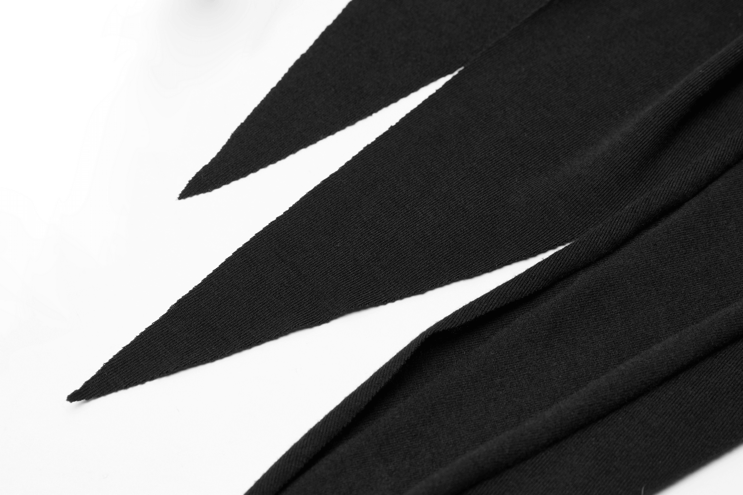 Close-up of black fabric with sharp asymmetrical cut details for a chic and modern knit dress.