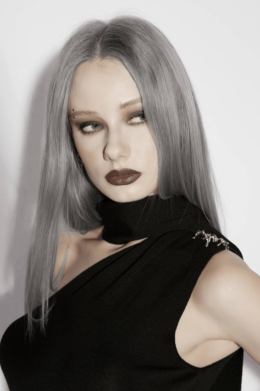 Model showcasing the Black Asymmetric Knit Gothic Top with Metal Pins, featuring a striking look.