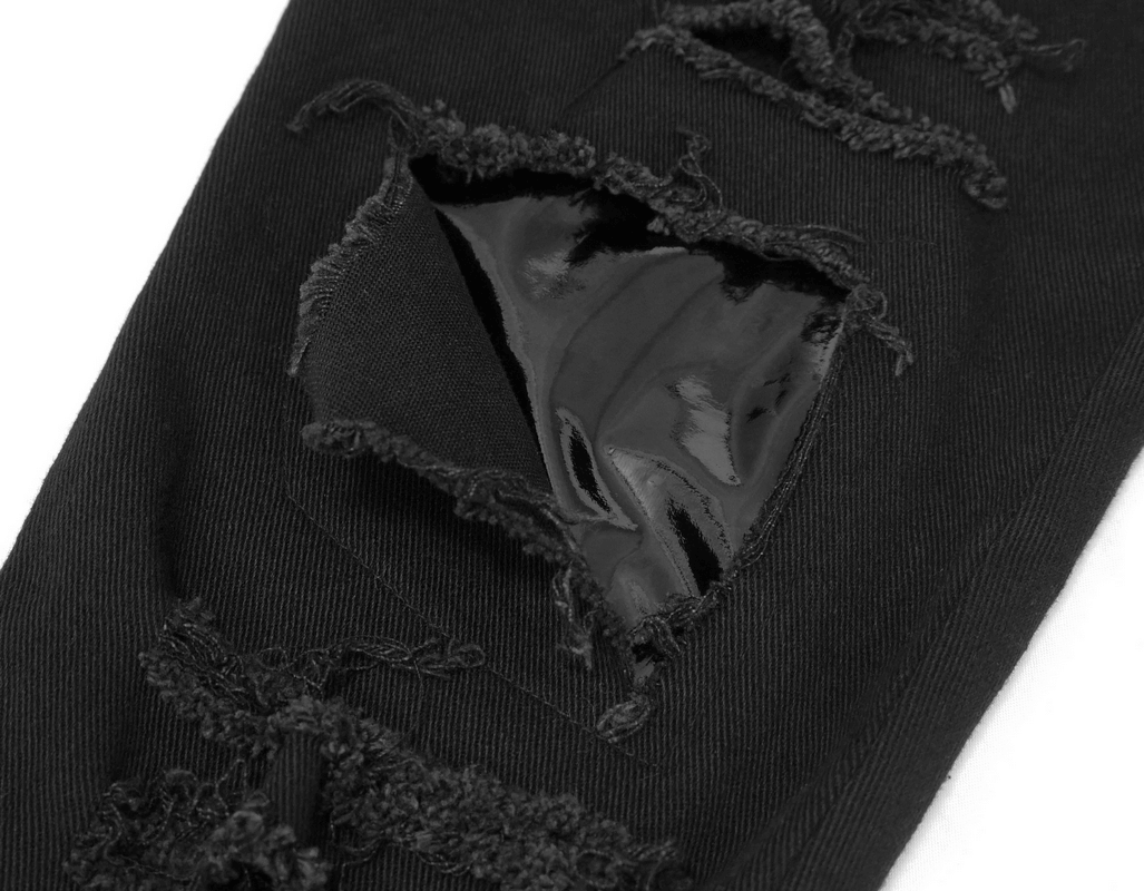 Close-up of black asymmetrical pants showcasing a ripped effect and glossy detail, perfect for a gothic style.