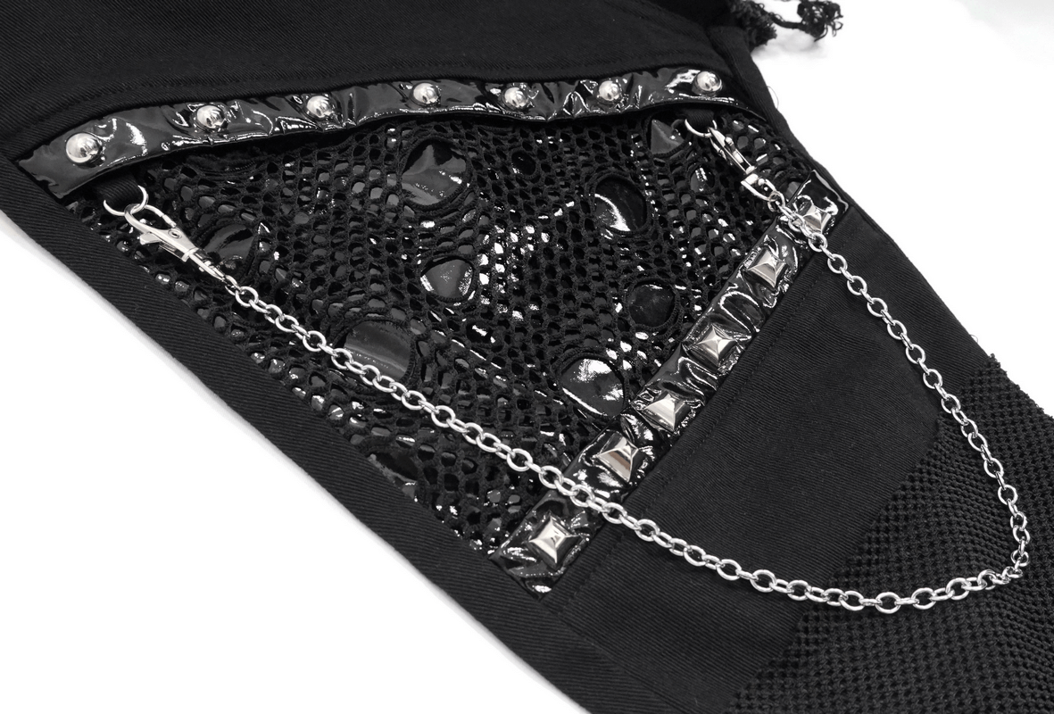 Close-up of black asymmetrical pants featuring silver rivets, chain detail, and mesh accents for a gothic style.