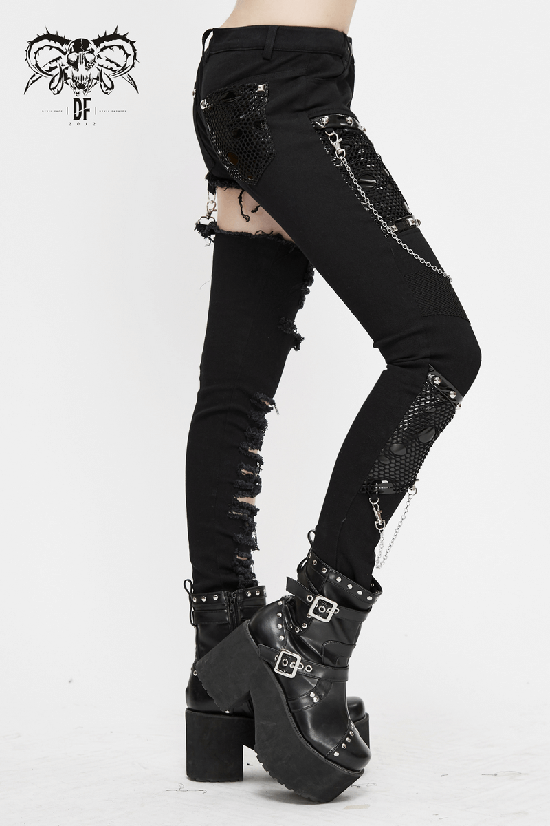 Black asymmetrical gothic skinny pants with ripped details and silver chains, paired with chunky platform boots.
