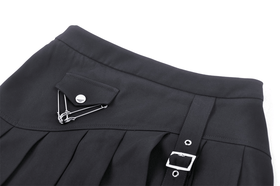 Close-up of black asymmetrical pleated punk skirt showcasing buckle detail and edgy safety pin accents.