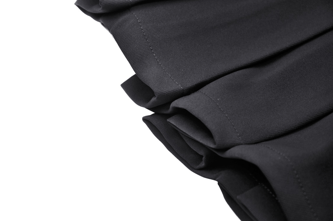 Close-up of black asymmetrical pleated punk skirt showcasing fabric texture and stylish folds.
