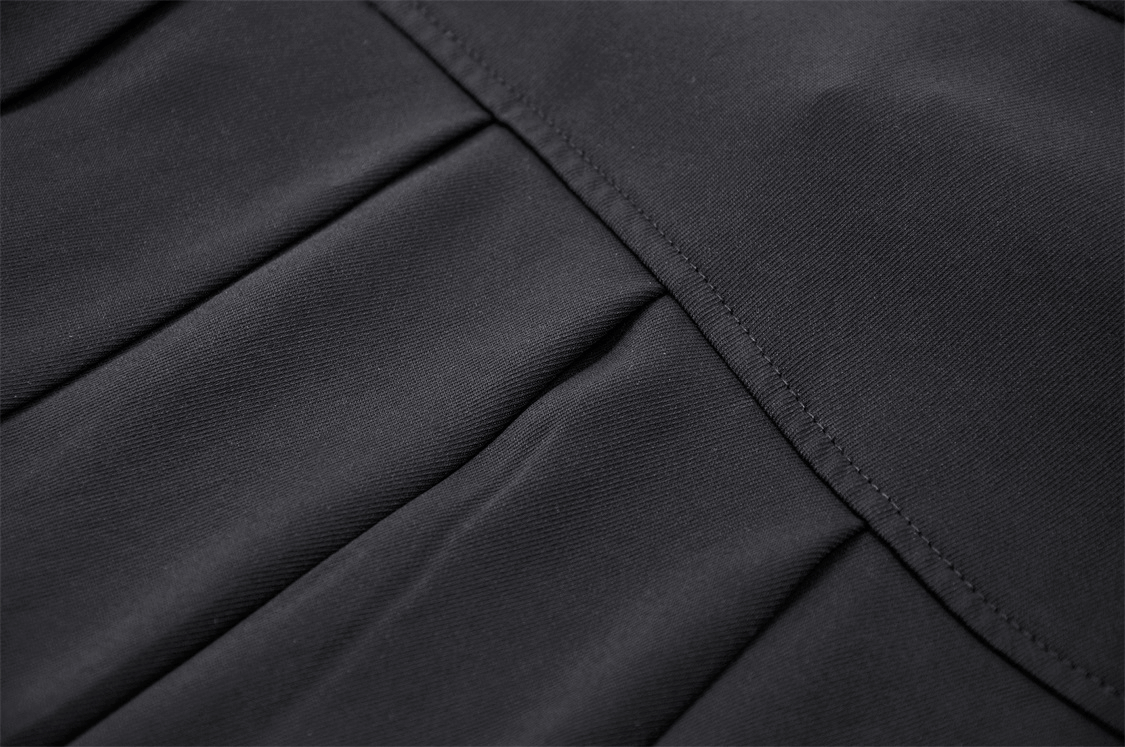 Close-up of black asymmetrical pleated fabric showcasing the edgy design of a punk skirt.
