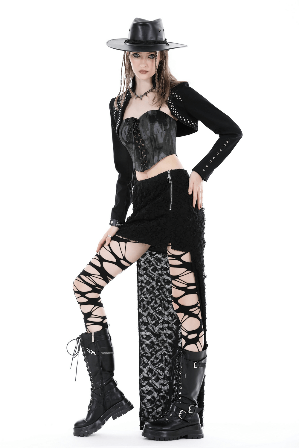 Stylish model in black bolero, corset, and laced skirt, exuding edgy fashion with bold accessories and combat boots.