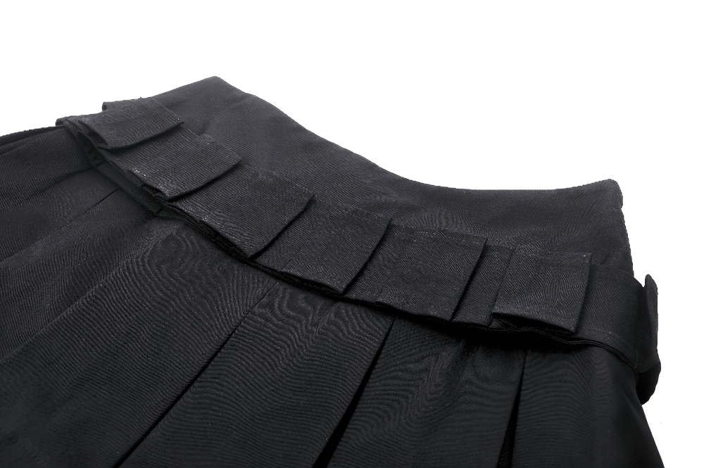 Close-up of black mini skirt with pleats and buckle accents, showcasing its edgy design and stylish details.