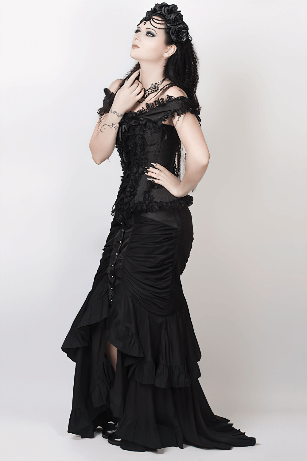 Elegant model wearing a black gothic skirt with ruffled layers and corset, showcasing gothic fashion style.