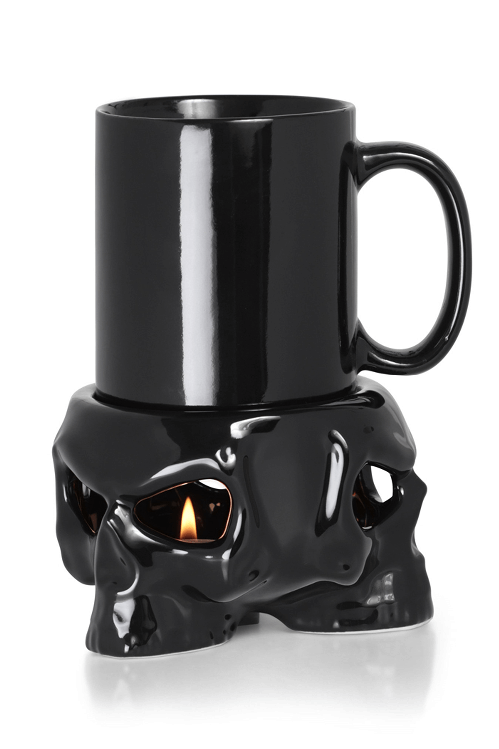 Black ceramic skull mug with tealight warmer stand, perfect for keeping drinks hot and adding gothic flair.
