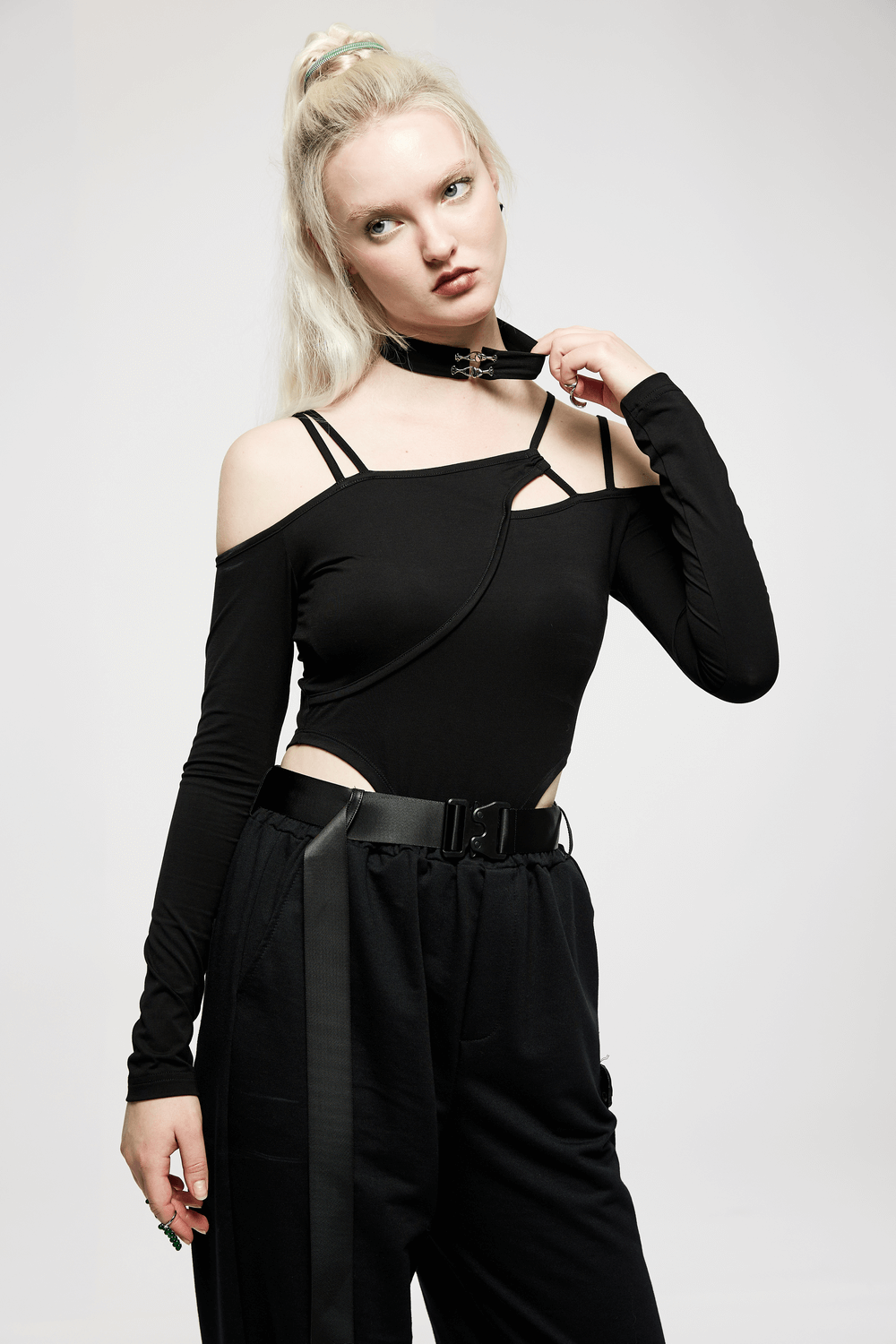 Model wearing a black asymmetric long sleeve bodysuit with choker neck, showcasing edgy fashion style.