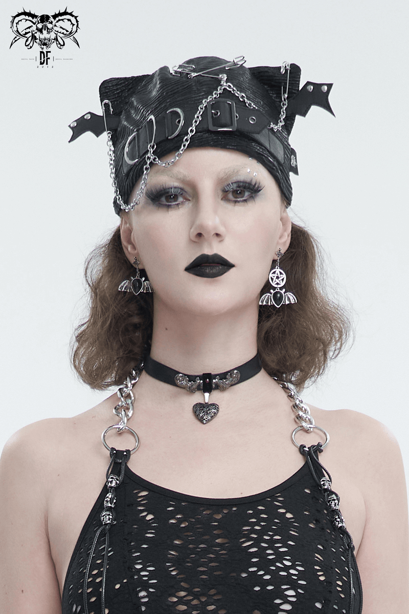 Gothic style woman in black batwing buckle hat, chains, and edgy accessories, exuding punk vibes.