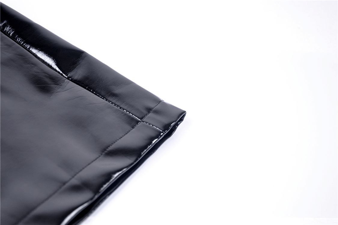 Close-up of the hemline of a black faux leather mini skirt showcasing sleek detail and shine.