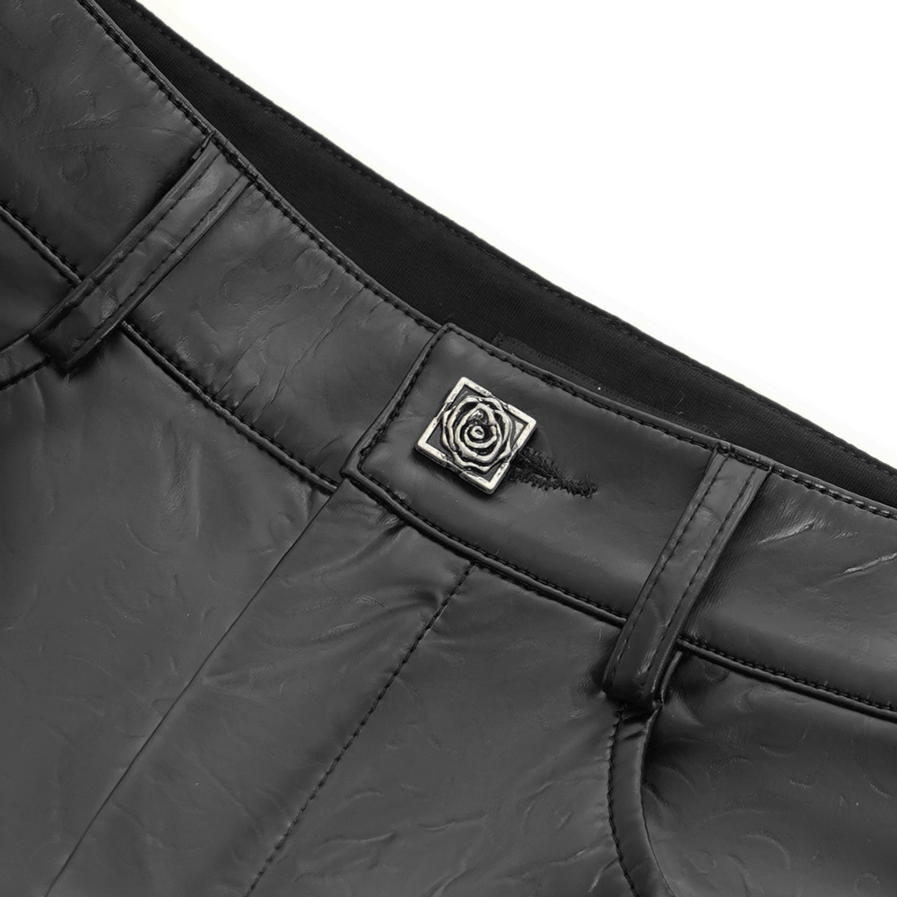Close-up of the high-waisted black faux leather pants featuring a stylish rose emblem detail.