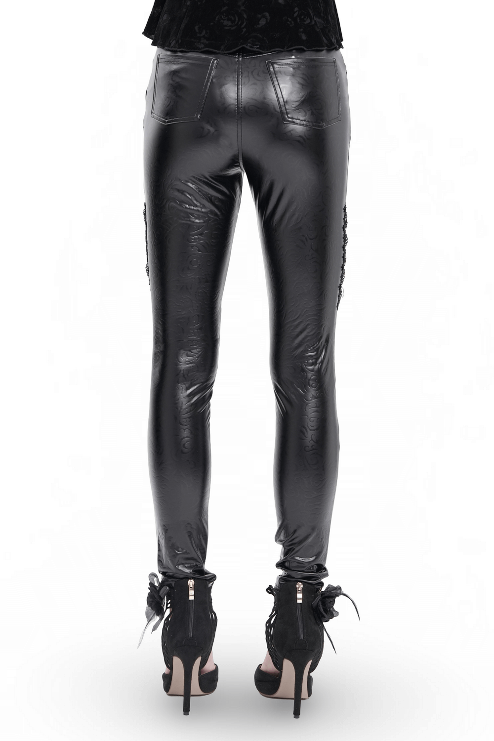 Rear view of black faux leather pants with chains and sequins, paired with stylish high-heeled boots.