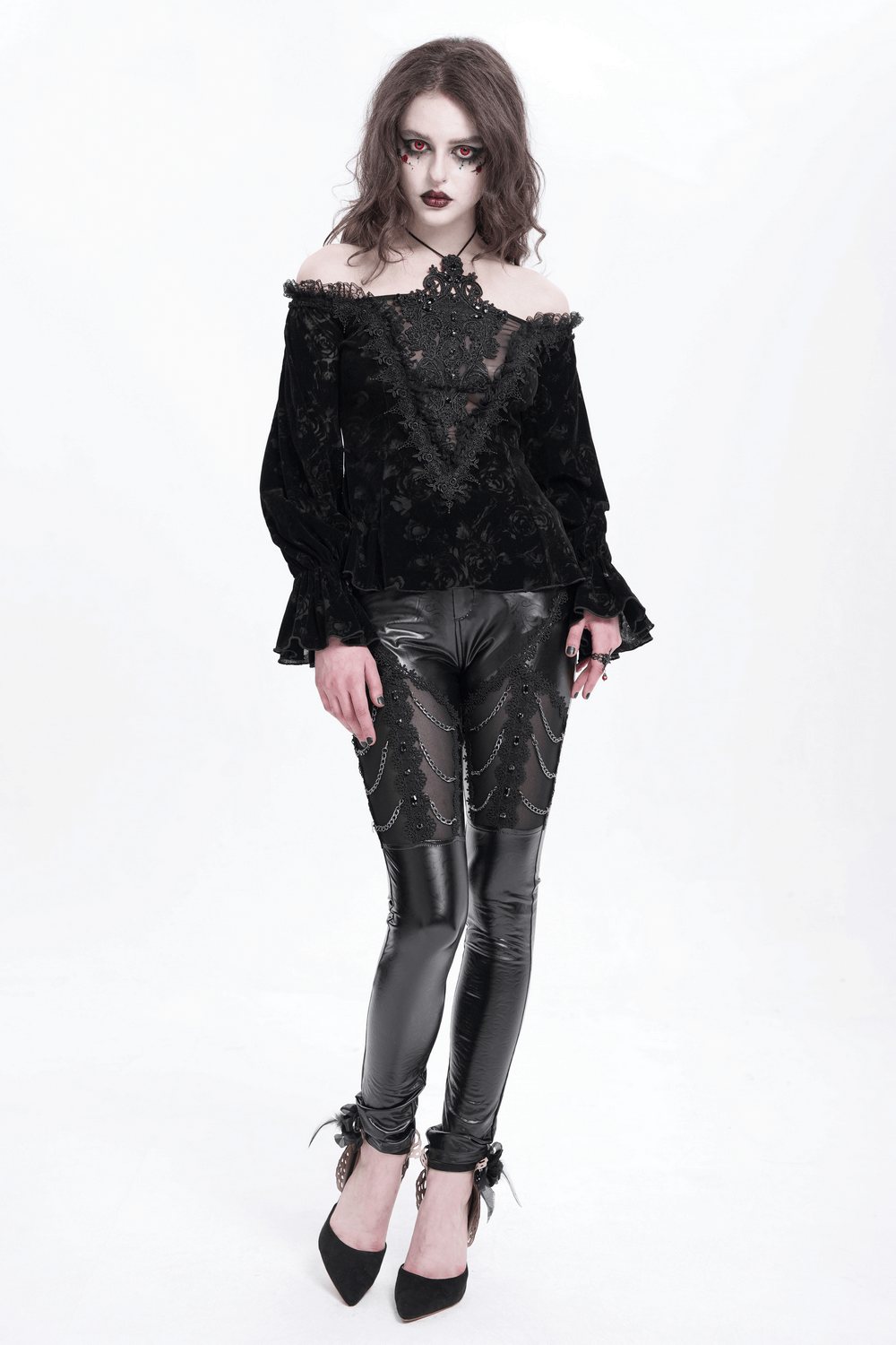 Model wearing black faux leather pants with chains and sequins, styled with a gothic top and dramatic makeup.