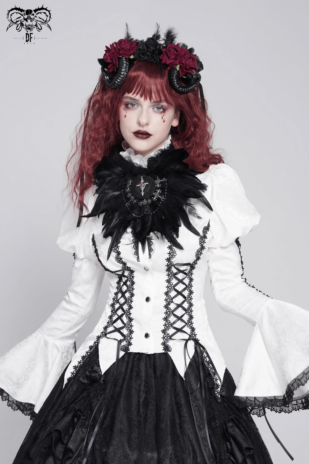 Gothic model wearing a black feather brooch and hair clip with lace and roses in a Victorian-inspired outfit.