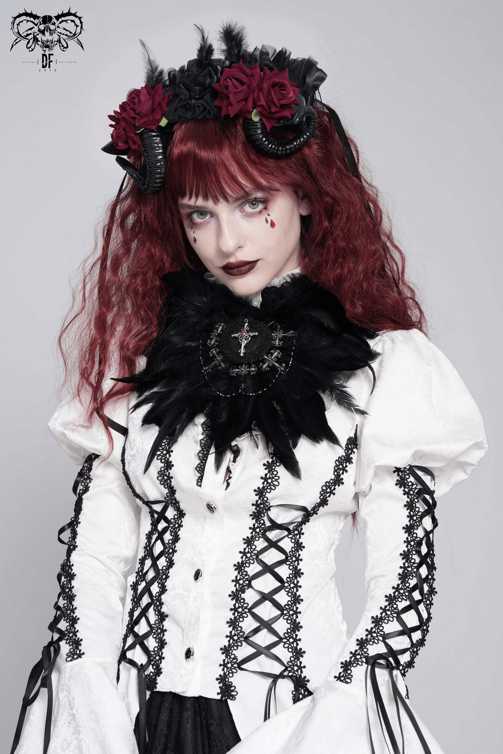 Gothic model in white Victorian blouse with black feather collar, rose crown, and dramatic makeup.