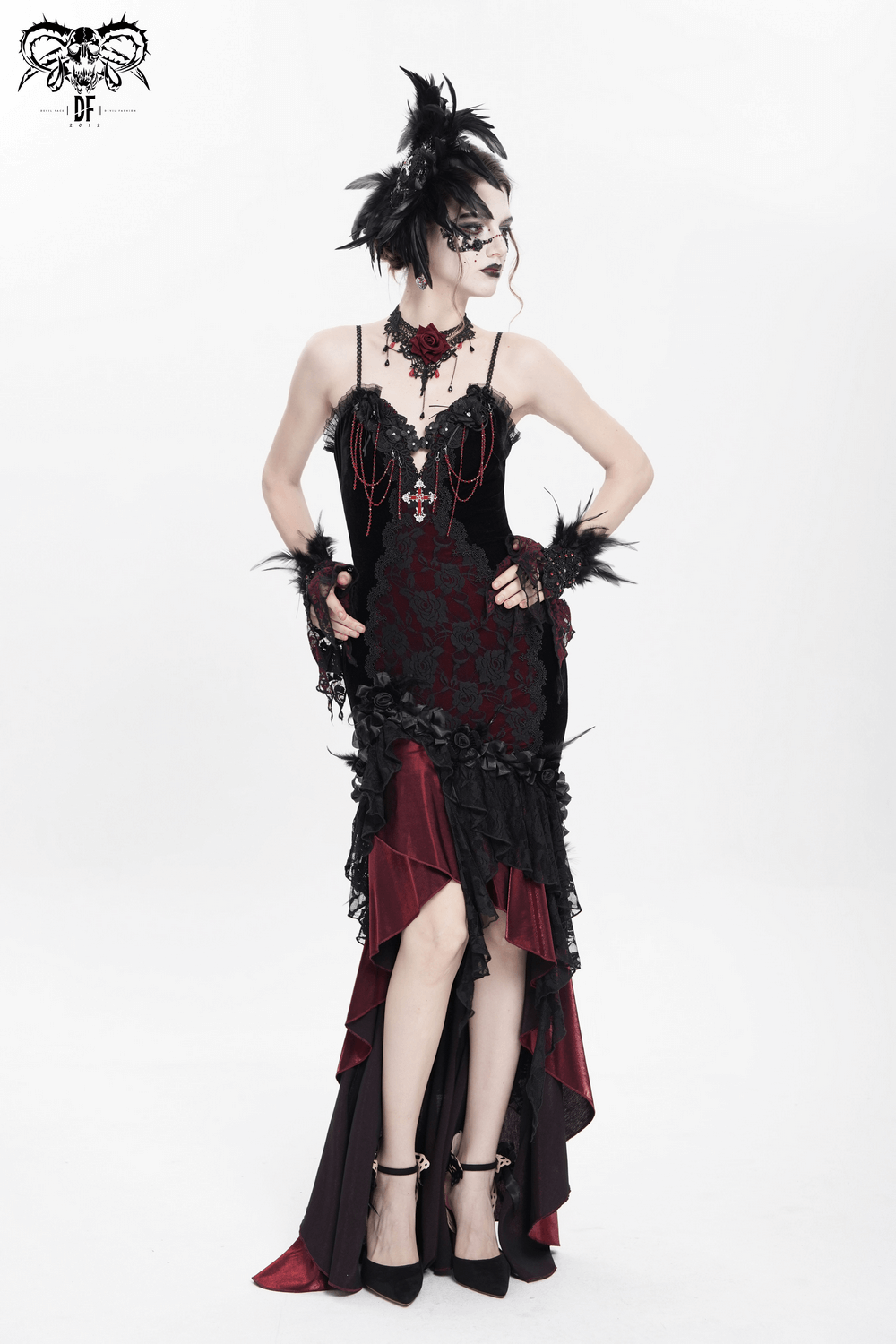 Gothic model in dramatic black and red dress with feather accents, lace, and ornate jewelry for a striking Victorian look.