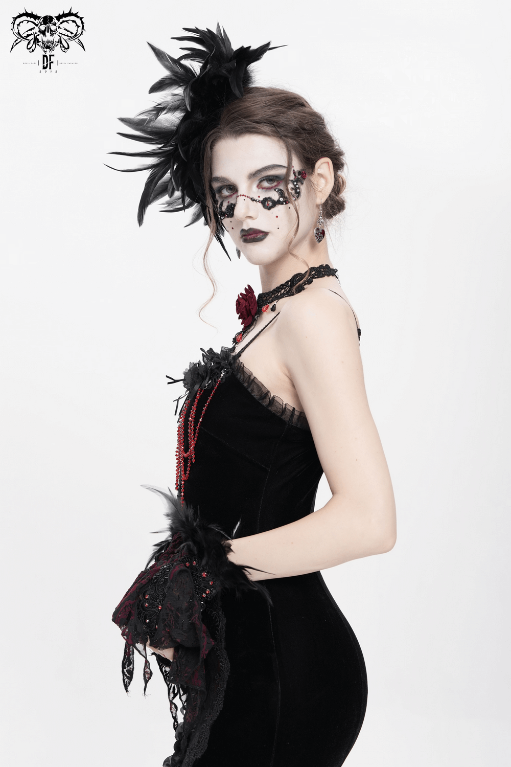 Gothic model showcasing a black feather brooch and hair clip with lace detail for a dramatic Victorian look.