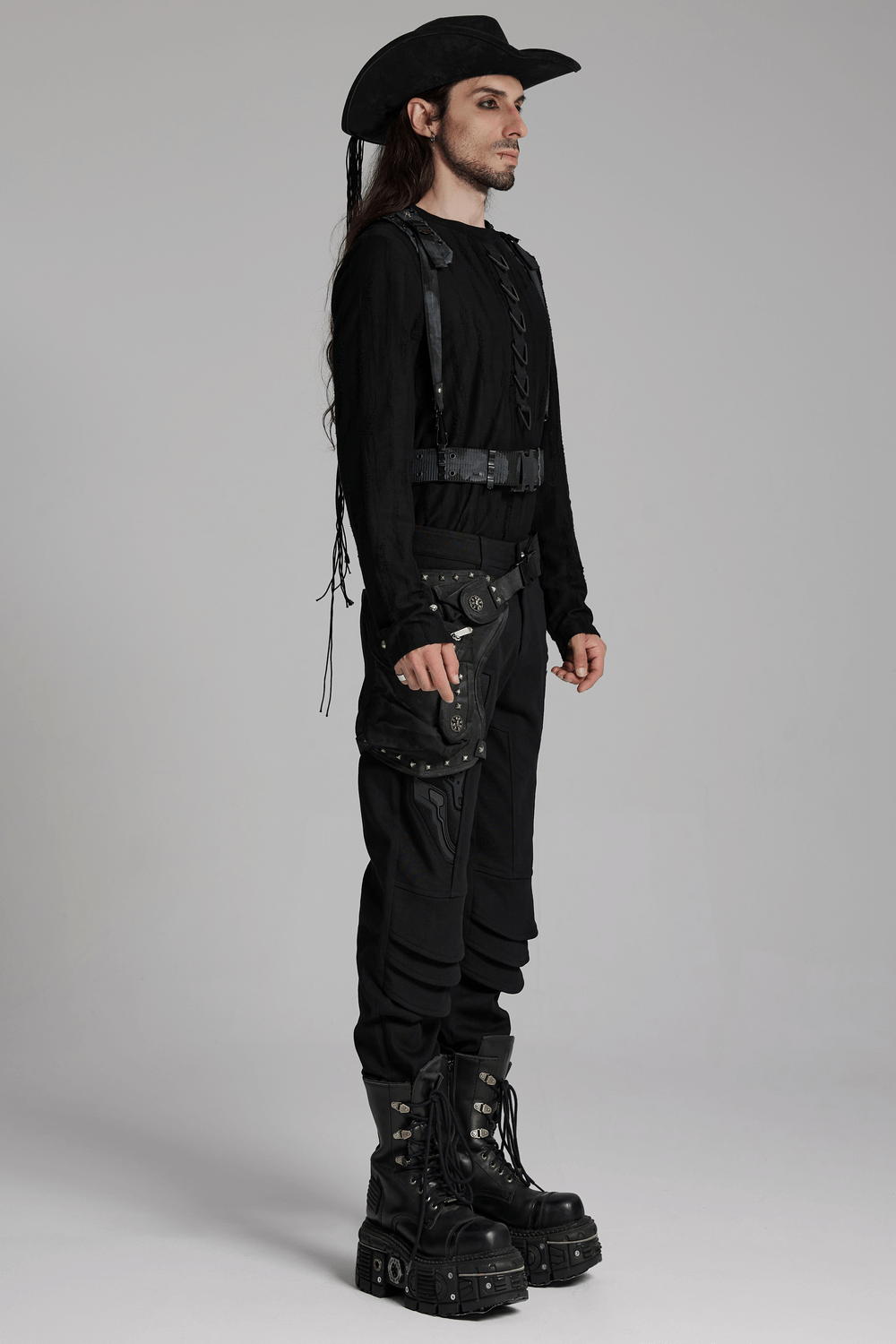 Model wearing black gothic cowboy hat with feather accents and braided band, showcasing a blend of dark style and gothic elegance.