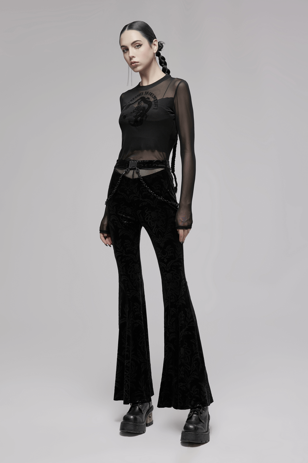 Gothic black floral velvet flared pants with mesh waist and chains, styled for a dramatic, edgy look.