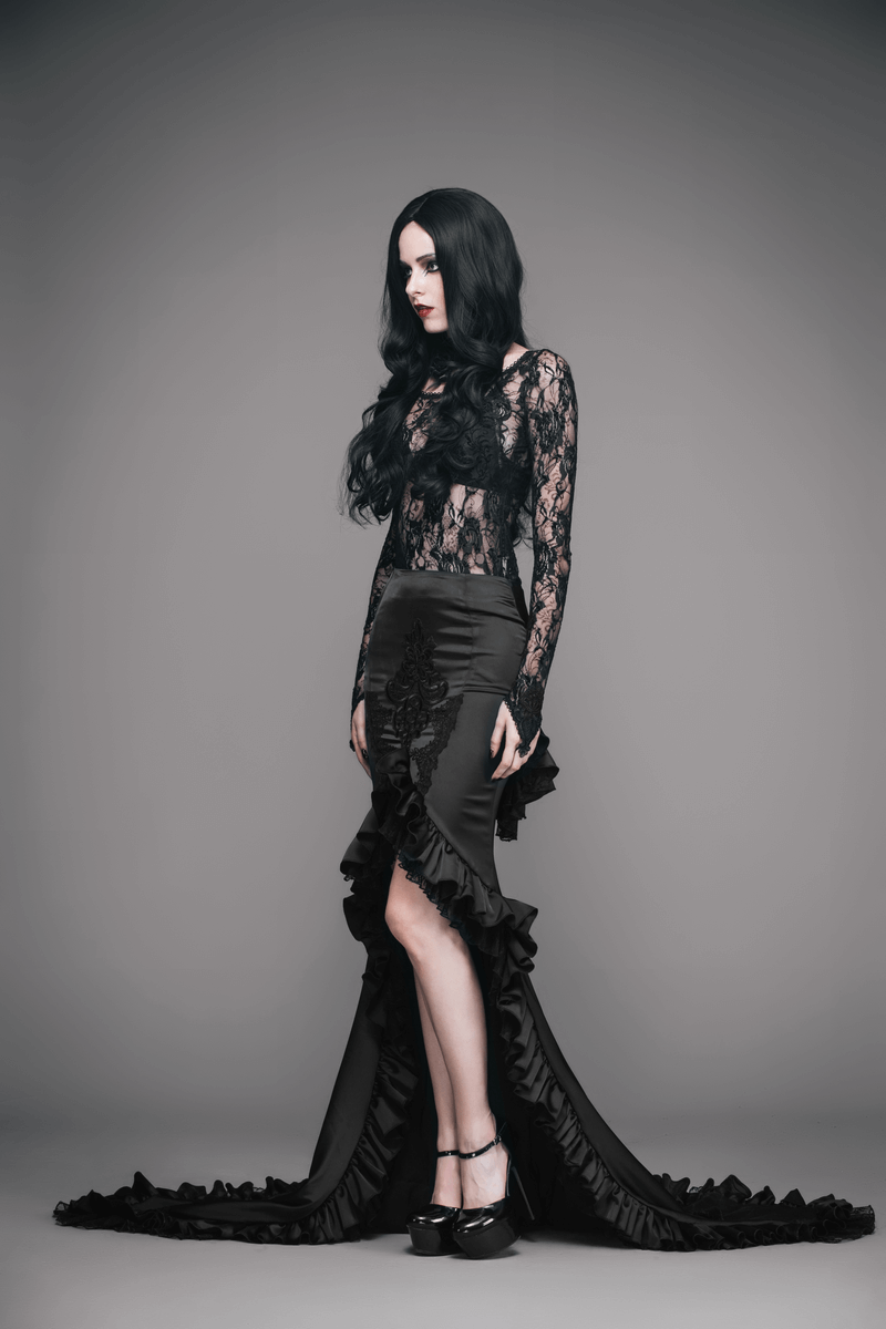 Elegant woman in a black frilled gothic skirt with long train and lace top, showcasing gothic fashion style.