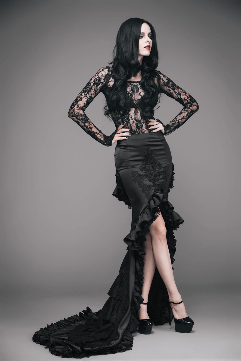 Elegant woman in black frilled skirt with long train and lace top, showcasing gothic fashion style.
