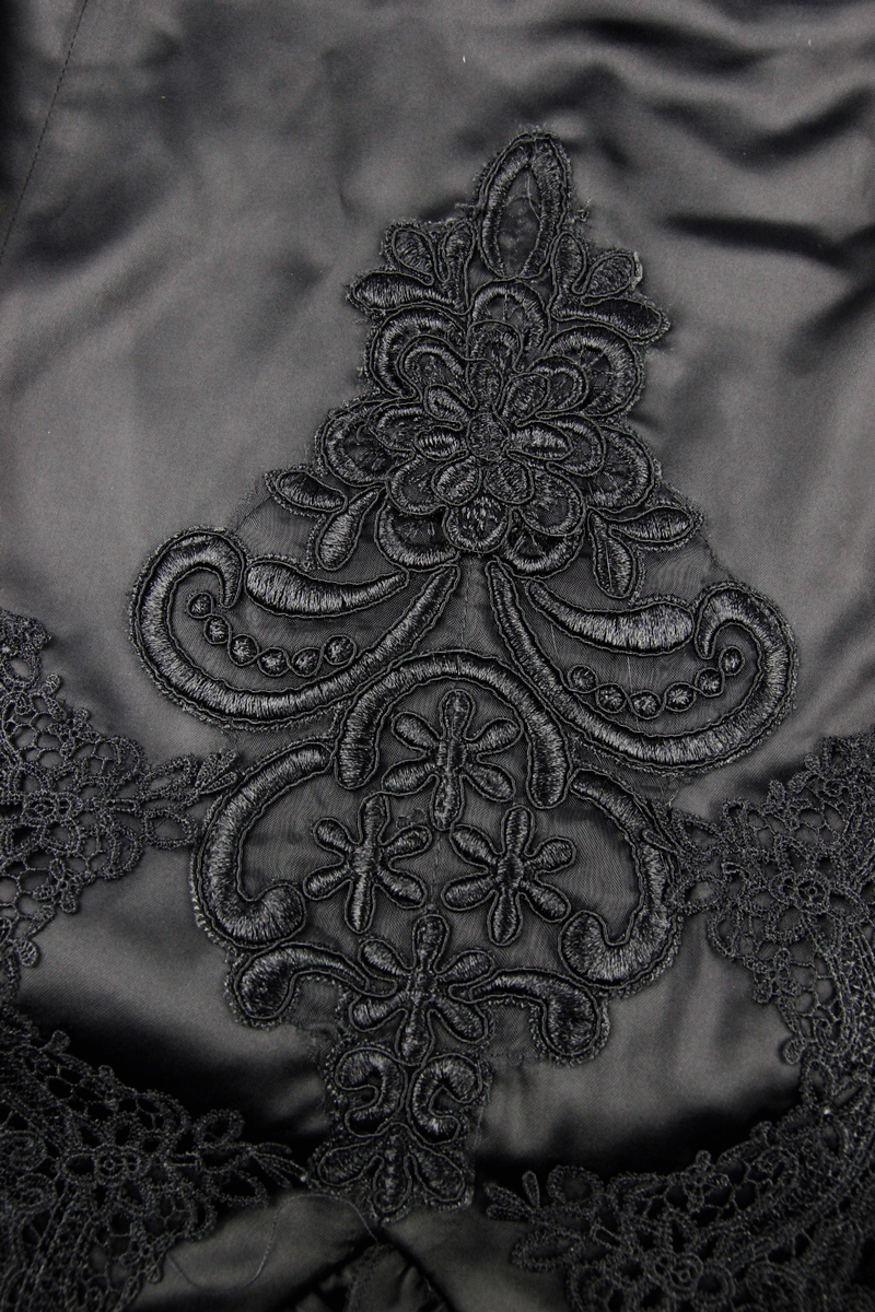 Intricate black lace embroidery detail on elegant gothic skirt fabric, showcasing vintage floral patterns.