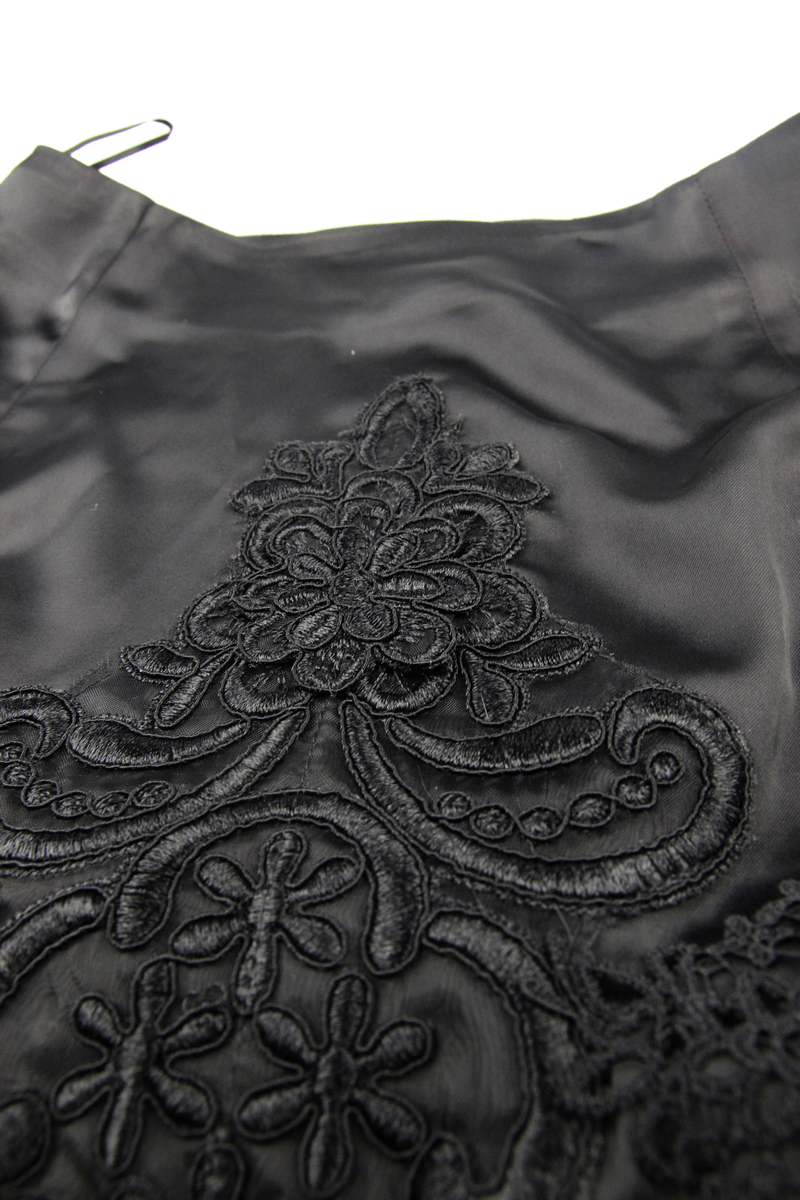 Close-up of elegant black embroidered fabric with intricate lace patterns for gothic skirts.