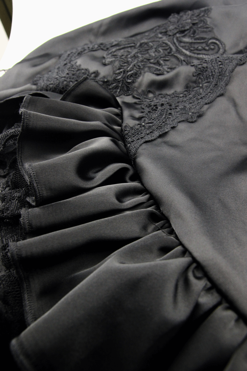Close-up of black frilled skirt featuring elegant lace detailing and ruffles, perfect for gothic fashion lovers.