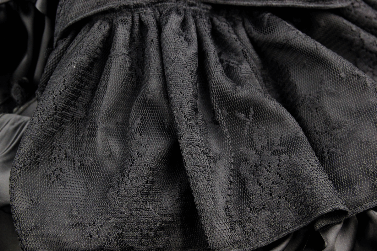 Close-up of the black frilled skirt showcasing intricate lace pattern and soft fabric texture.