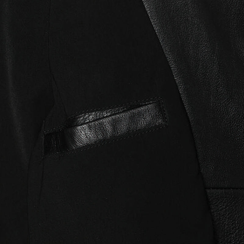 Close-up of the black genuine leather biker jacket showing the sleek pocket design and texture.