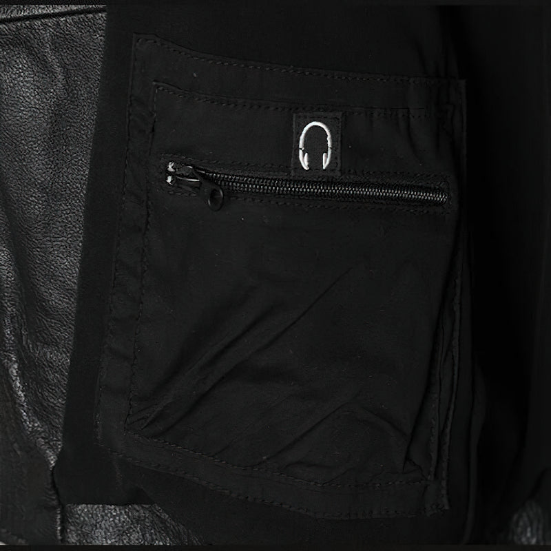 Close-up of black leather biker jacket pocket featuring zipper for secure storage.