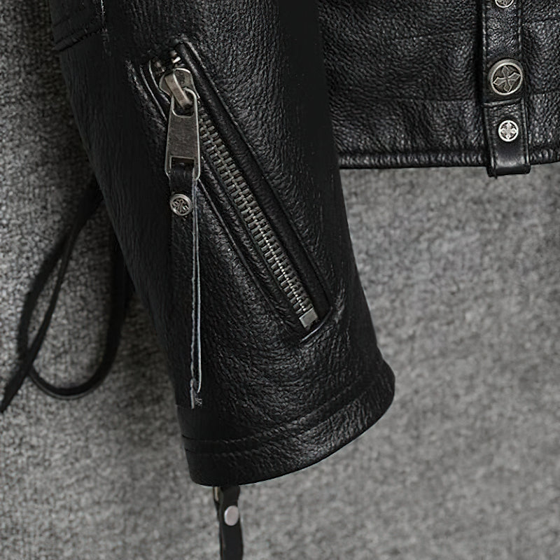 Detail of a black genuine leather biker jacket showcasing a zippered pocket and stylish metal buttons.