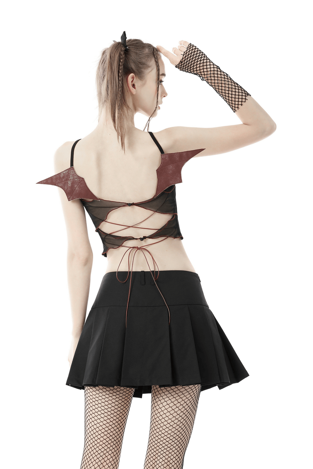 Back view of a model wearing a black gothic batwing crop top with edgy design and fishnet gloves.