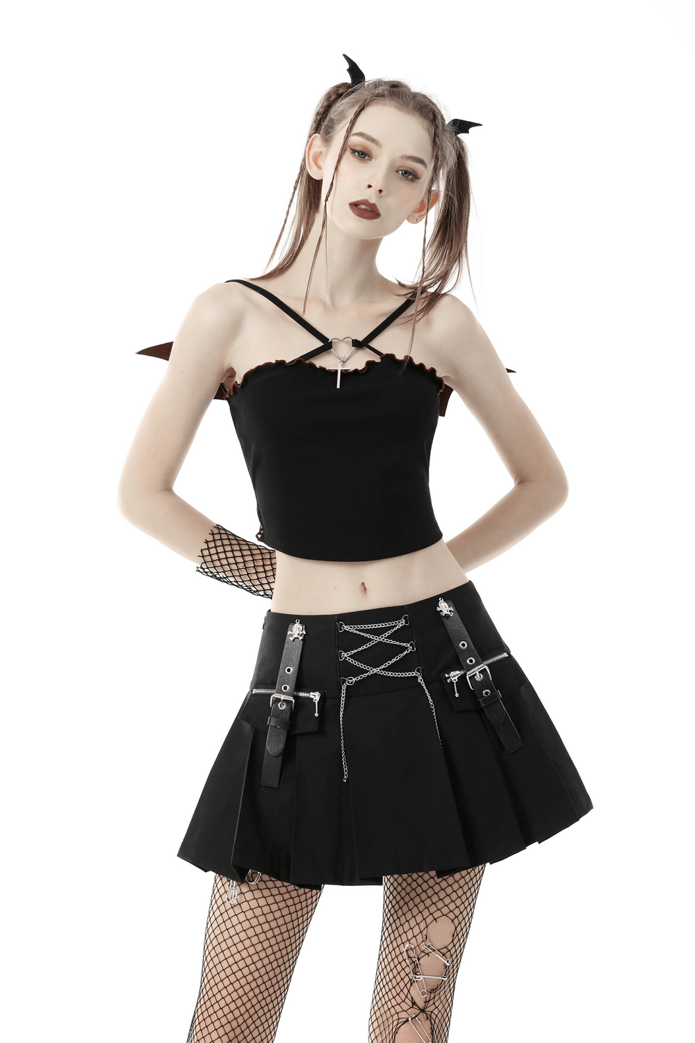 Model wearing a black gothic batwing crop top with edgy design, paired with a black skirt and fishnet stockings, showcasing punk rock style.