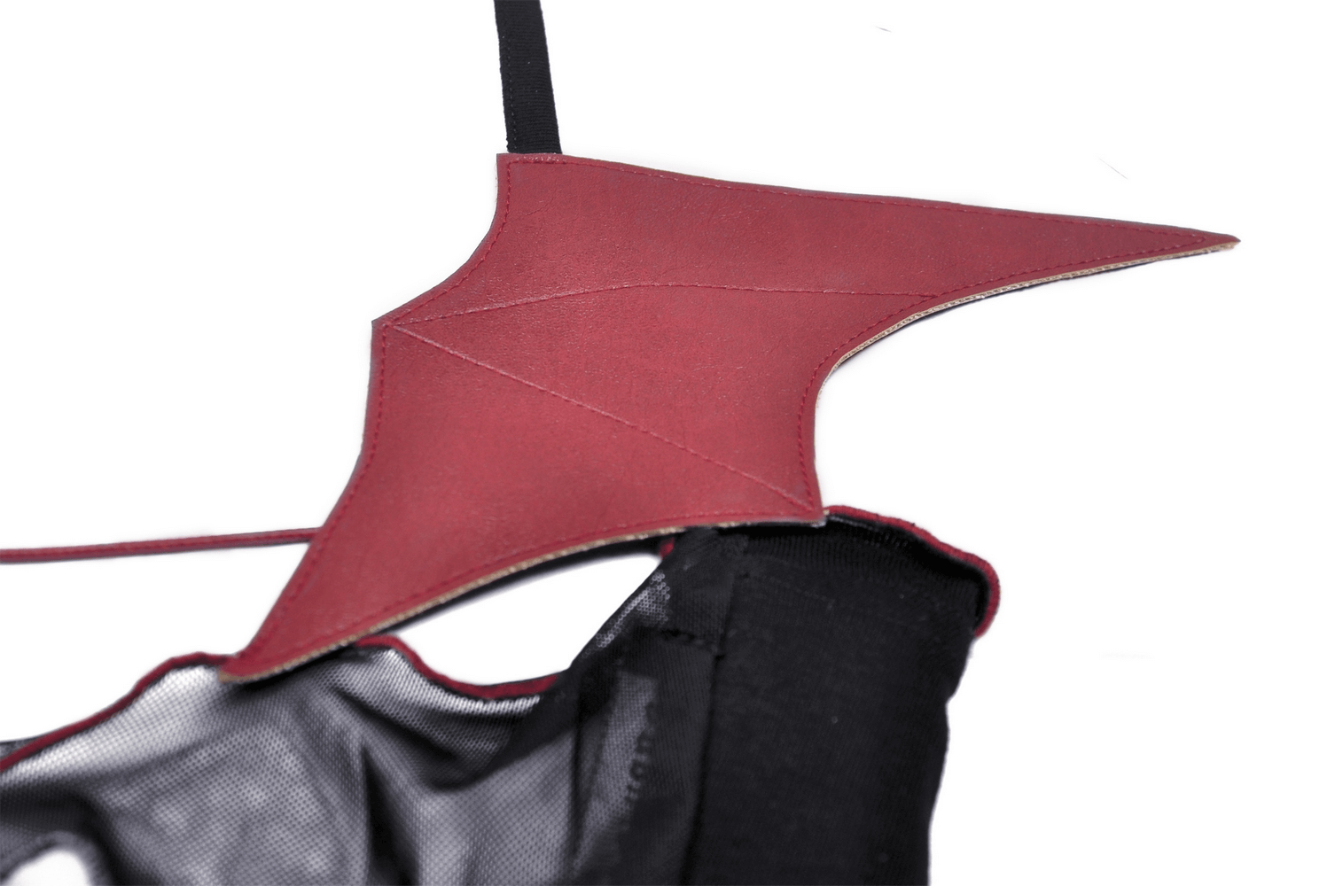 Close-up of the dramatic batwing design on a black gothic crop top, showcasing edgy red fabric details.