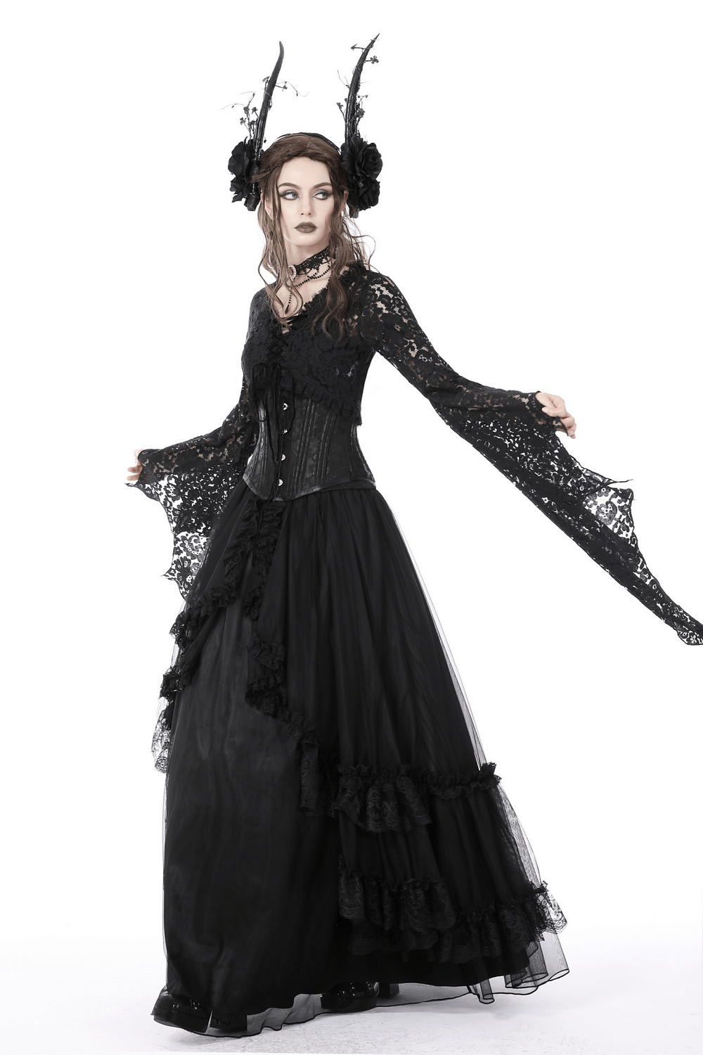 Gothic model in black lace outfit with flowing skirt and dramatic sleeves, embodying dark Victorian elegance.