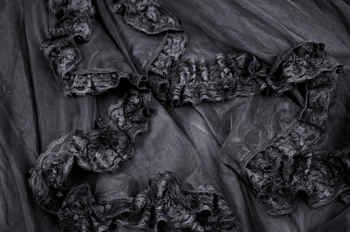 Close-up of black chiffon fabric with lace accents, perfect for gothic high-low skirts or Victorian-inspired fashion.
