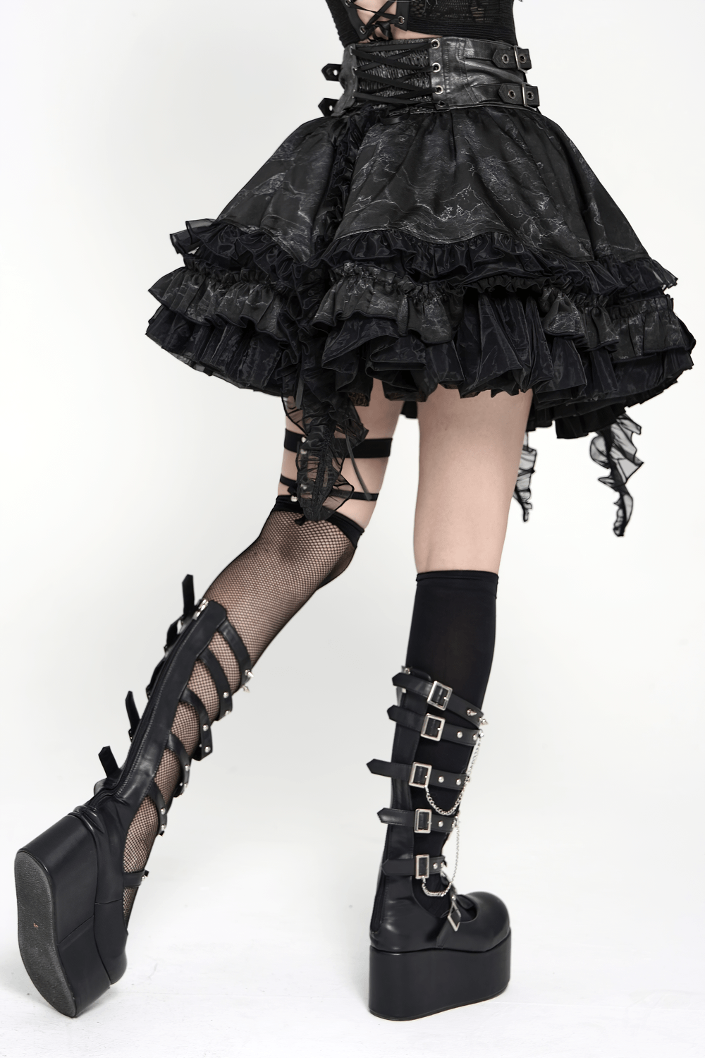 Black Gothic Corset Ruffle Mini Skirt with Chains paired with stylish platform boots, showcasing layered ruffles and edgy detail.