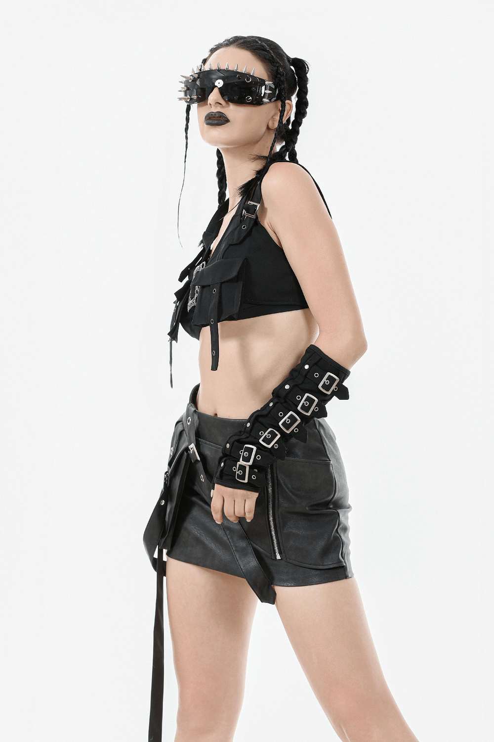 Black Gothic crop top with buckles and metal details, paired with a short leather skirt and edgy accessories.
