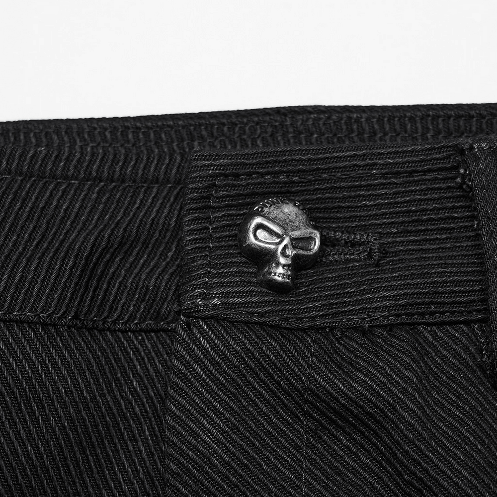 Close-up of a black denim skirt featuring a skull button accent for a punk gothic style.