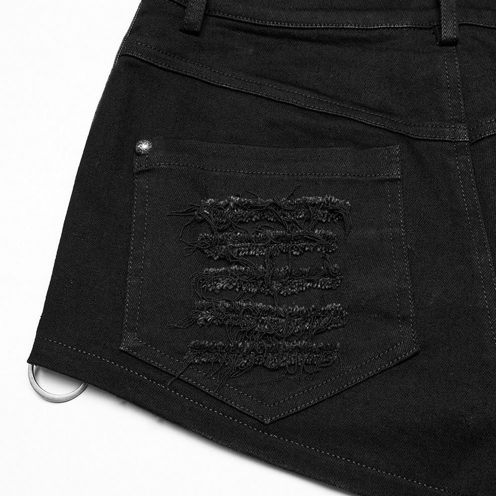 Close-up of black gothic distressed denim shorts featuring eyelets and edgy frayed back pocket detail.