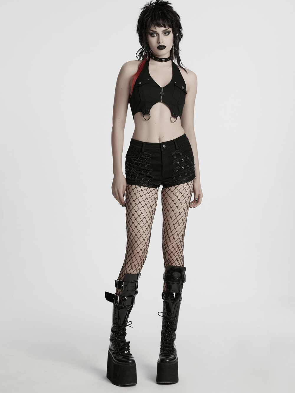 Black gothic distressed denim shorts with eyelets, styled with a cropped top and fishnet stockings.