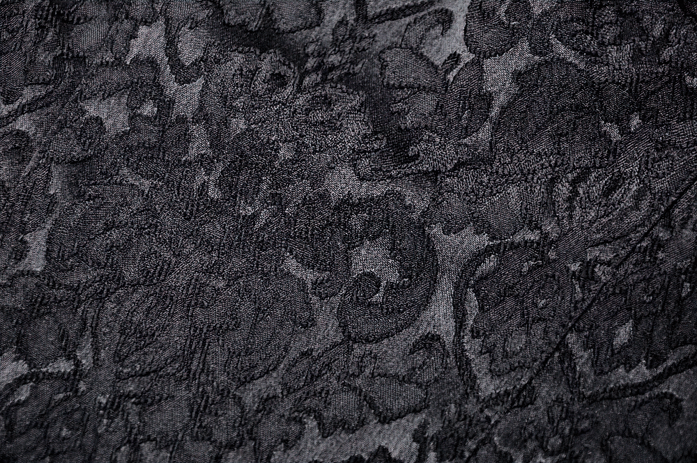 Close-up of intricate black lace fabric with floral patterns, perfect for a Gothic style top.