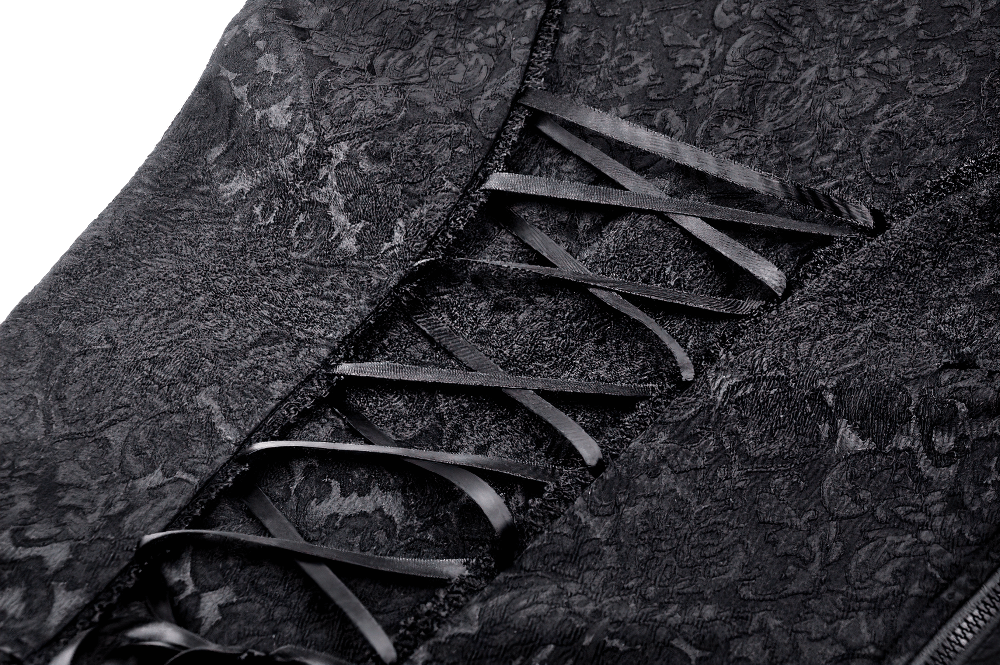 Close-up of black lace fabric with intricate patterns and stylish ribbon lacing for a gothic look.