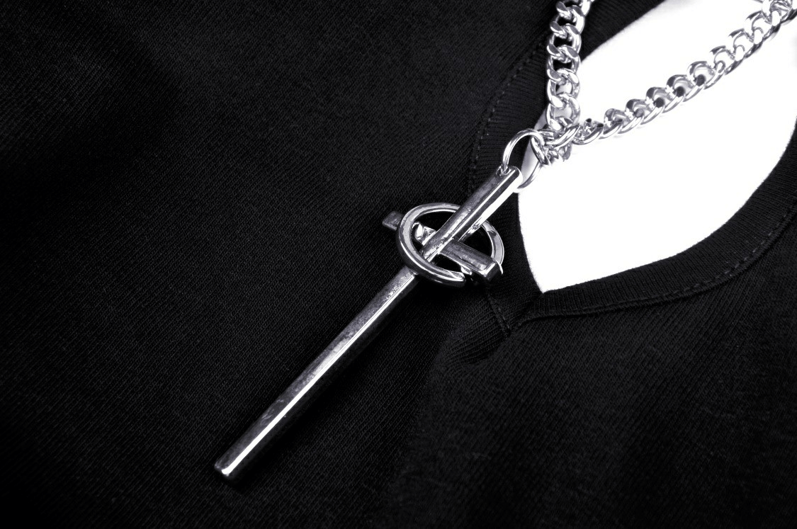 Close-up of silver chain detail on a black gothic halter crop top, showcasing edgy punk fashion style.