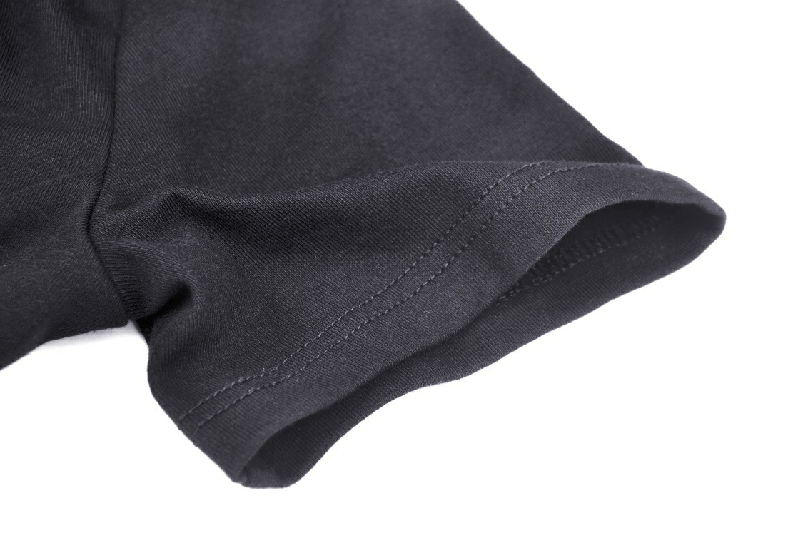 Close-up of the hem of a black gothic halter crop top, showcasing soft fabric and detailed stitching.