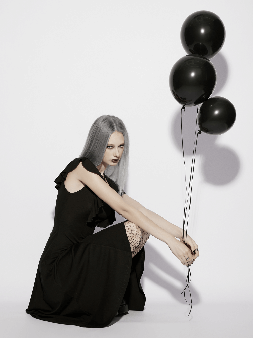 Alt Tag: Black Gothic High Low Dress with Ruffle Sleeves model holding black balloons, lace-up back, dramatic ruffle sleeves, high-low hem
